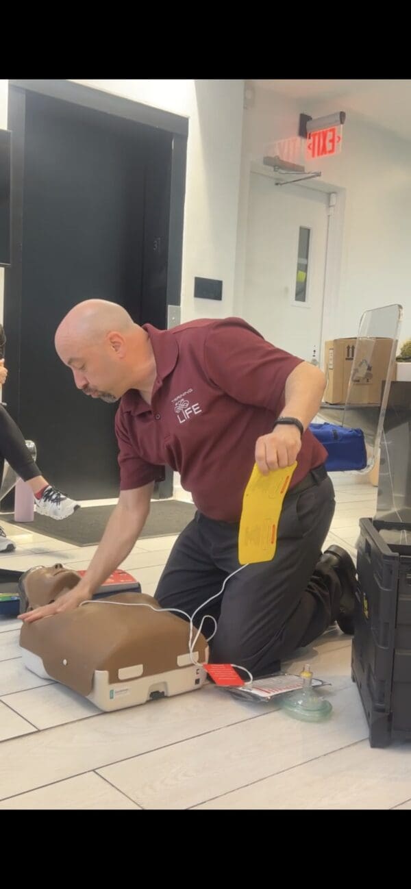 Instructor demonstrating CPR on mannequin.