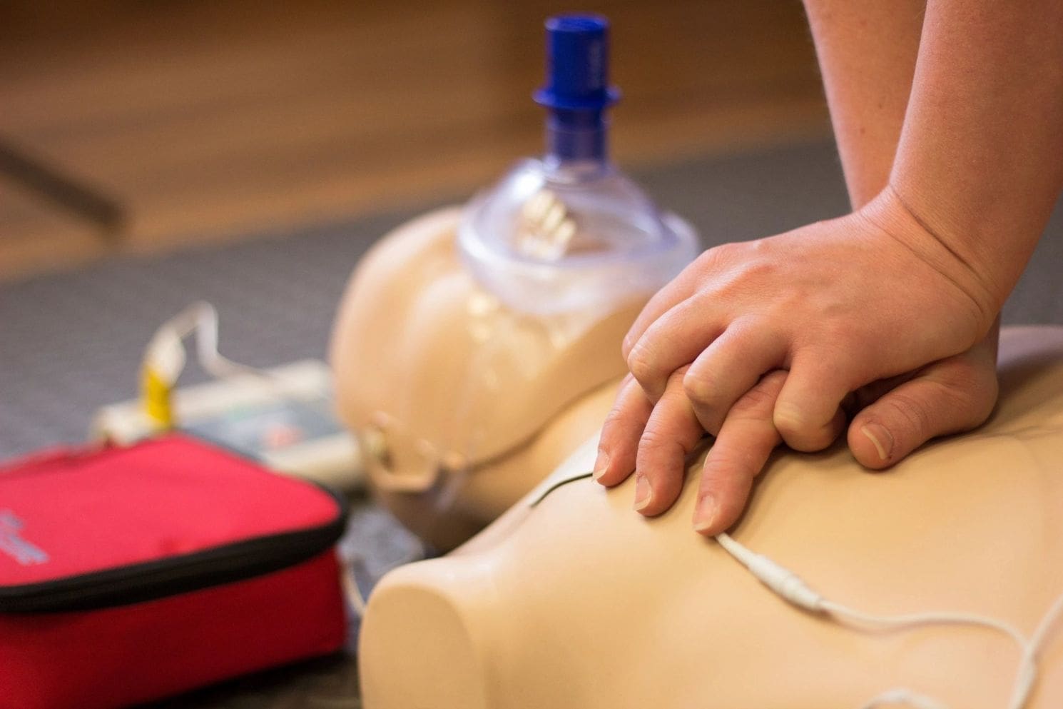 A person is holding their hands on the chest of an infant.